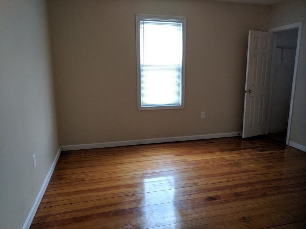 121 Winfield Street Worcester, MA 01602 - Photo 31 of 42 a view of an empty room with wooden floor and a window