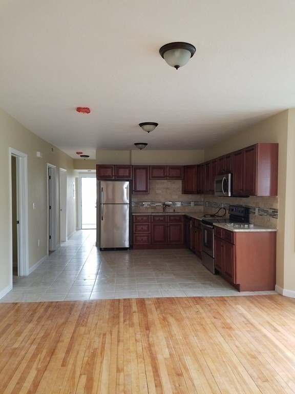 121 Winfield Street Worcester, MA 01602 - Photo 8 of 42 a large kitchen with a lot of cabinets and wooden floor