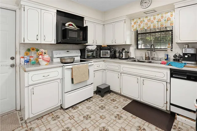 a kitchen with stainless steel appliances kitchen island granite countertop a refrigerator a stove a sink dishwasher and white cabinets with wooden floor