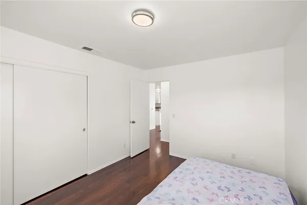 an empty room with wooden floor and closet
