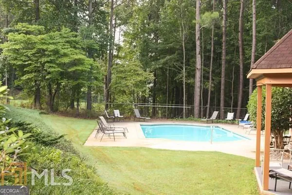 a view of a swimming pool with a patio and a yard