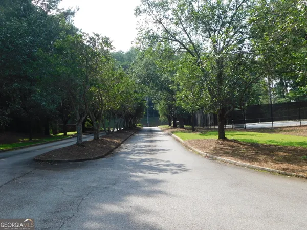 a view of a swimming pool with a big yard and large trees