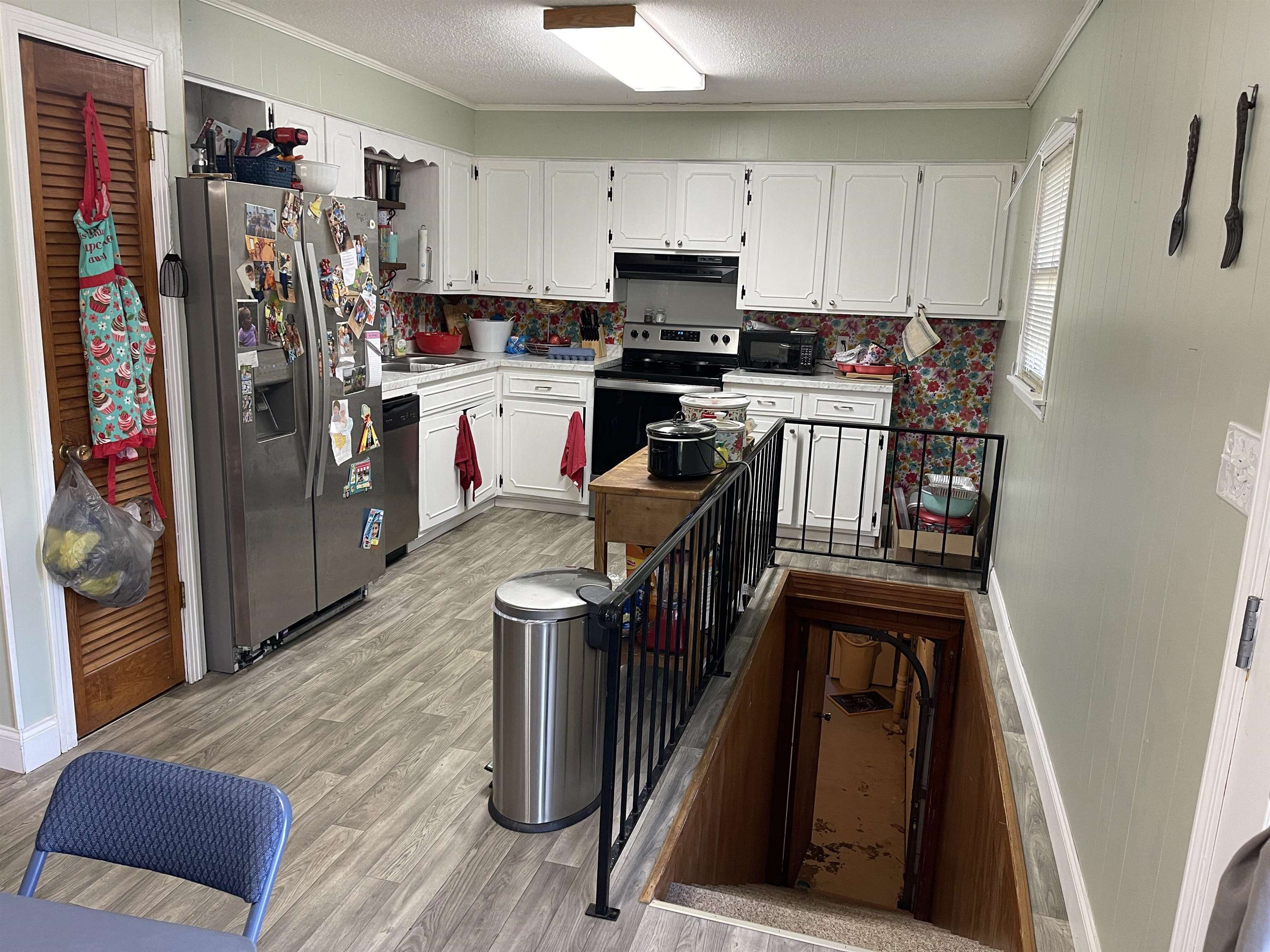 81 Puron Road Adamsville, TN 38310 - Photo 10 of 40 a kitchen with stainless steel appliances granite countertop a refrigerator a stove a sink dishwasher and white cabinets with wooden floor