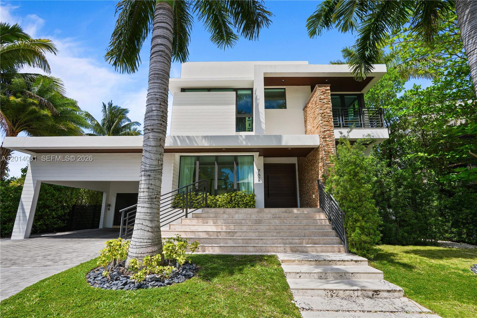 762 Fernwood Road Key Biscayne, FL 33149 - Photo 1 of 82 a front view of a house with a yard and potted plants