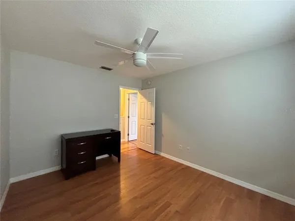 an empty room with a window and wooden floor
