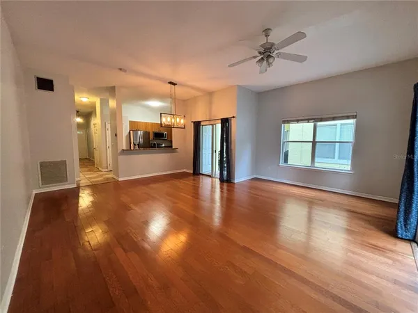 a view of a big room with wooden floor and a window