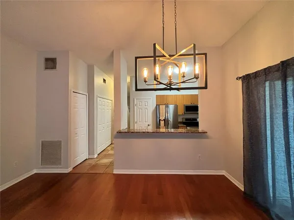 a view of a living room with wooden floor and a flat screen tv