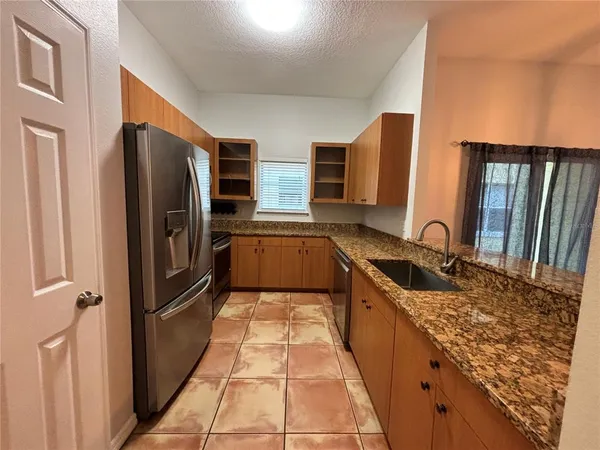 a kitchen with stainless steel appliances granite countertop a refrigerator and a sink
