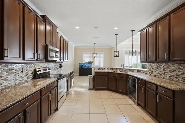 a large kitchen with stainless steel appliances kitchen island granite countertop a stove refrigerator and cabinets