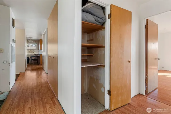 a view of a hallway with wooden floor and a living room