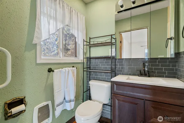 a bathroom with a sink a toilet and a mirror