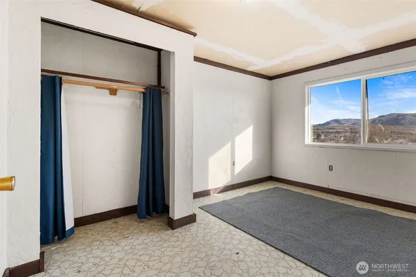 an empty room with windows and closet