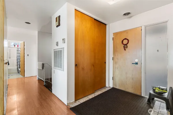 a view of a hallway with bathroom and wooden floor