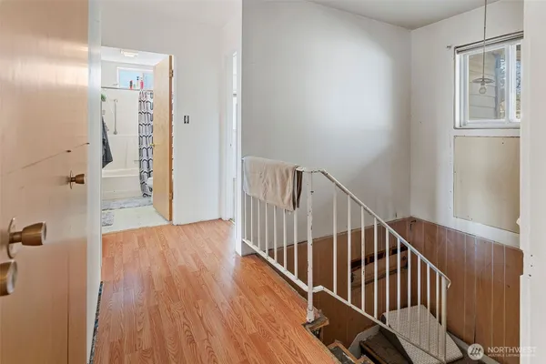 a view of a hallway with wooden floor and entryway