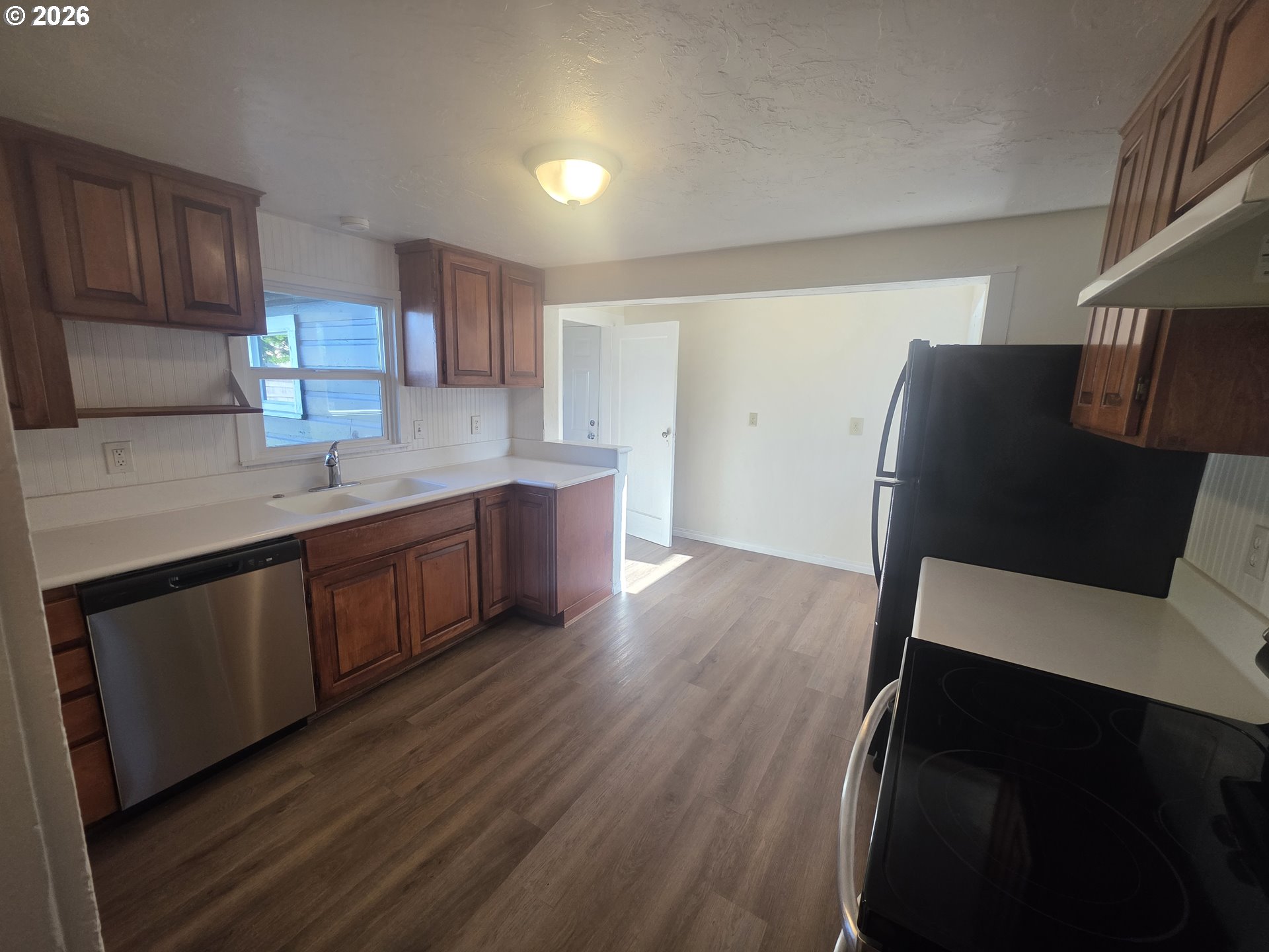 770 Elm Street Junction City, OR 97448 - Photo 18 of 30 a kitchen with stainless steel appliances granite countertop a refrigerator a sink dishwasher and wooden cabinets with wooden floor