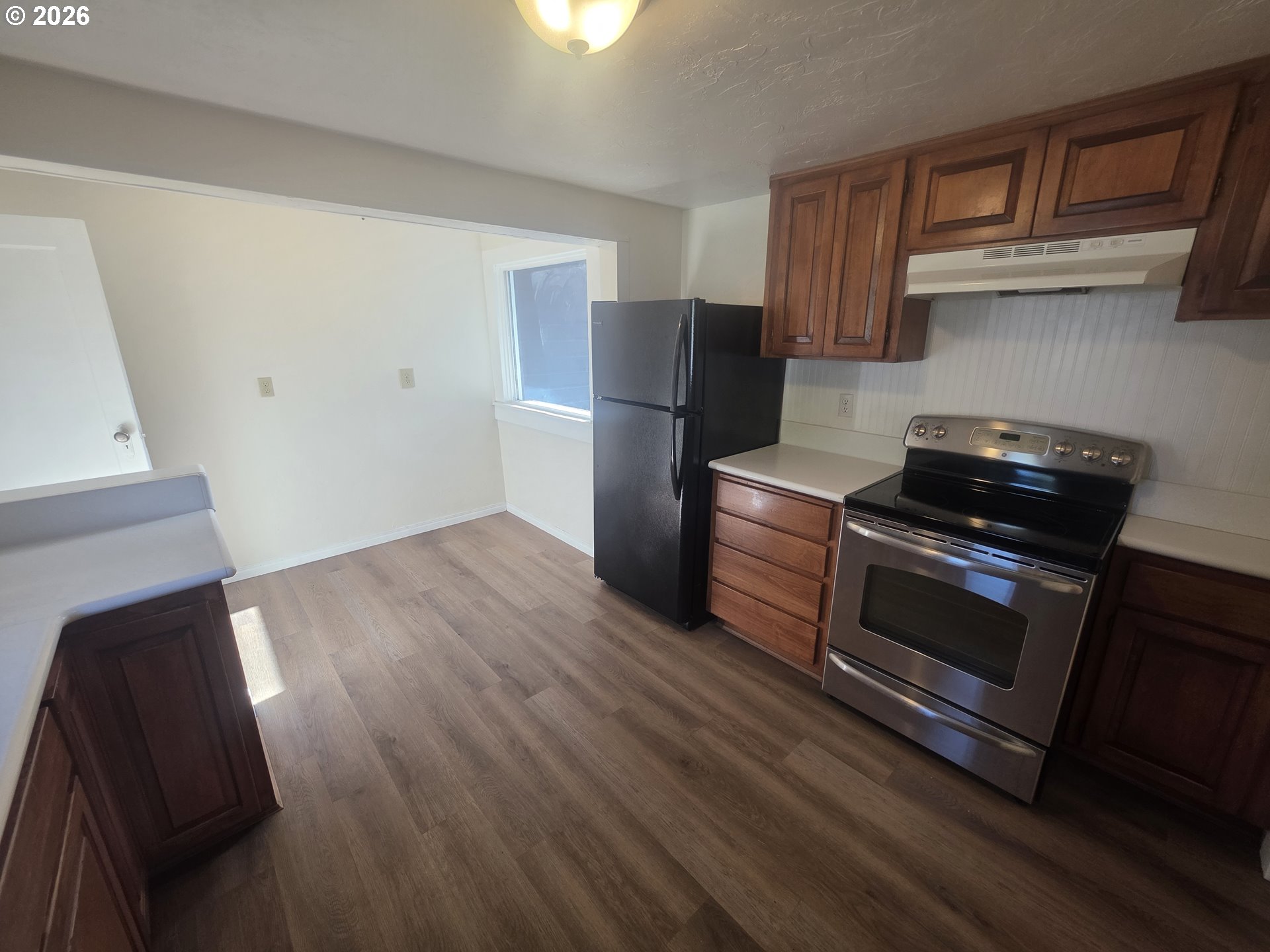 770 Elm Street Junction City, OR 97448 - Photo 19 of 30 a kitchen with wooden floors and black appliances