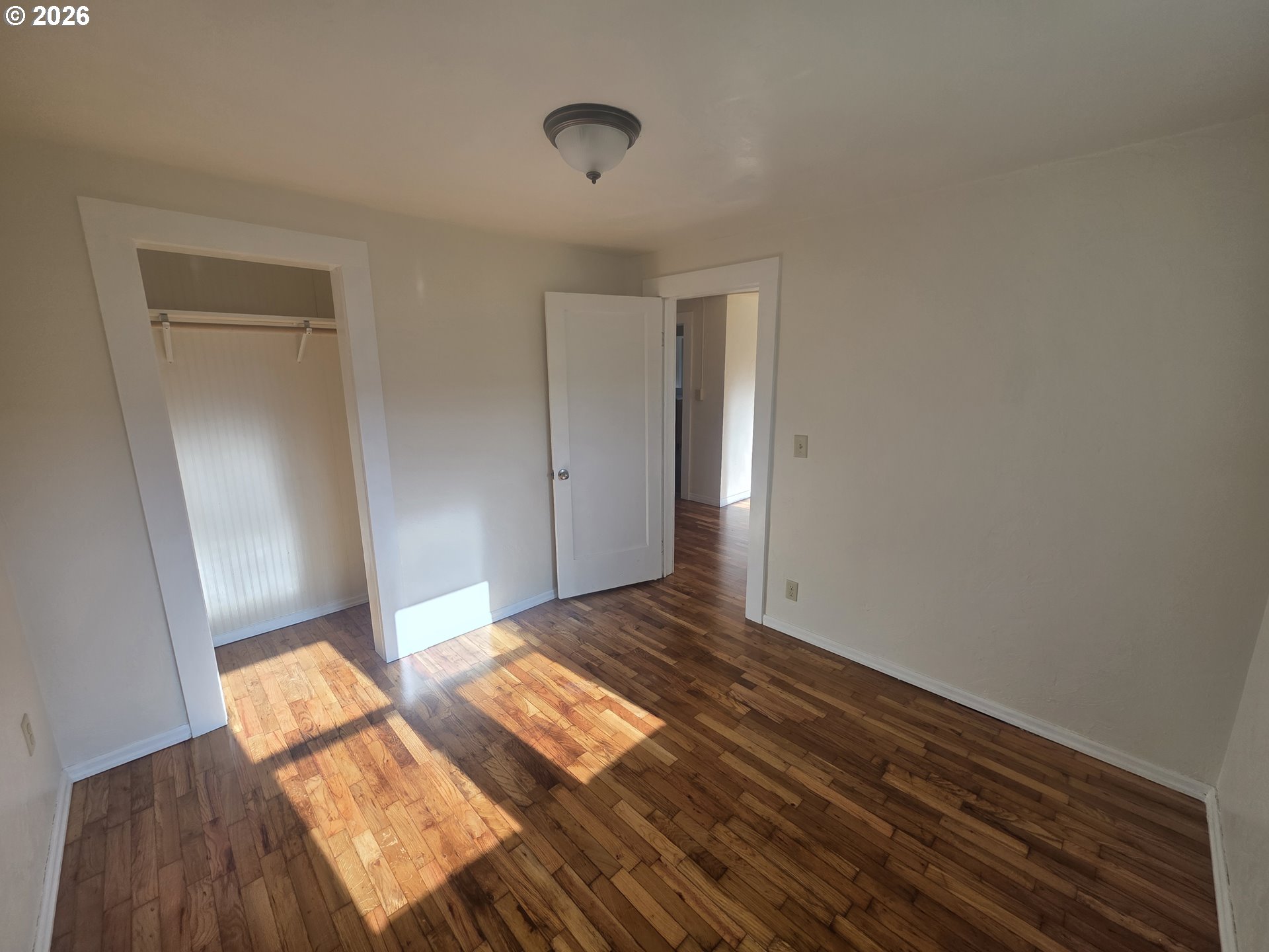 770 Elm Street Junction City, OR 97448 - Photo 10 of 30 a bedroom with a bed and wooden floor