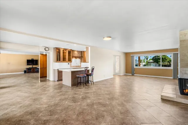 a living room with kitchen island granite countertop furniture and a large window