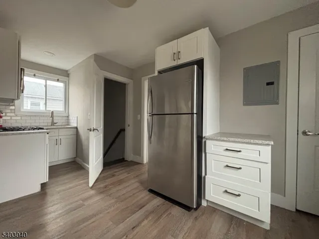 a kitchen with a refrigerator a stove and a wooden floor