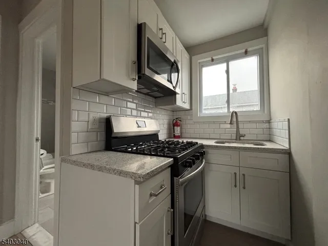 a kitchen with stainless steel appliances granite countertop a stove sink and cabinets