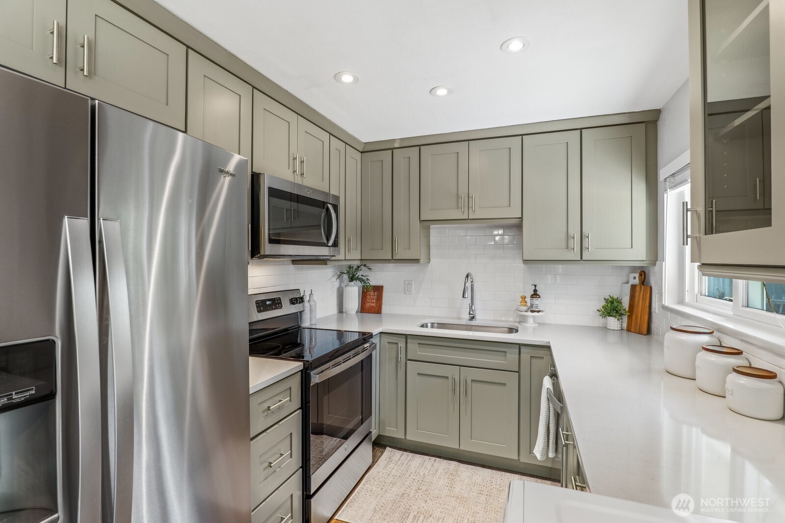 3923 Northeast 22nd Place Renton, WA 98056 - Photo 8 of 21 a kitchen with a sink a refrigerator a microwave and cabinets