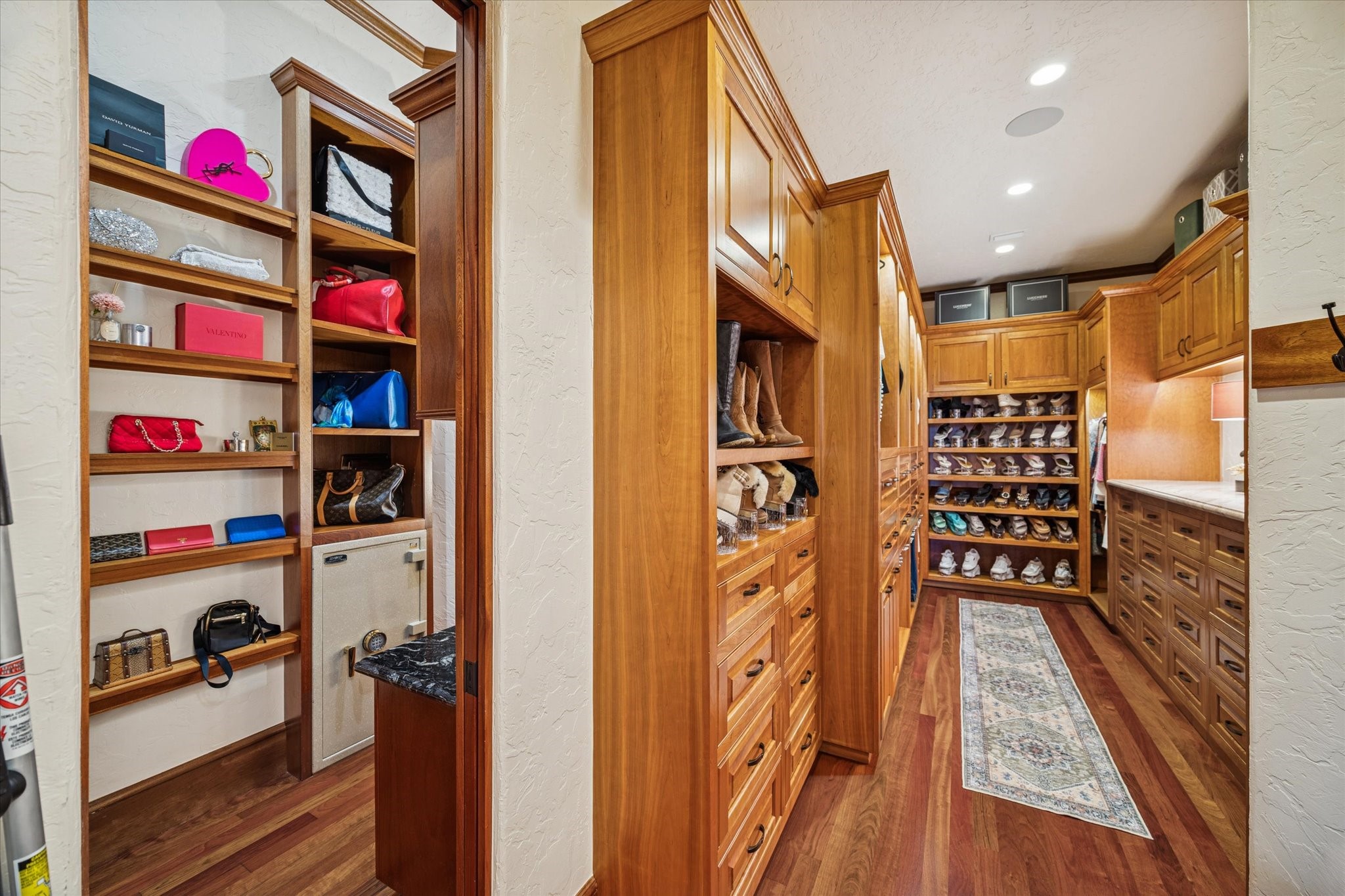 21538 Mueschke Road Tomball, TX 77377 - Photo 20 of 50 Primary en-suite walk-in closets. This spacious retreat extends into two separate walk-in closets, thoughtfully designed for privacy and convenience. Custom mahogany cabinetry with drawer systems offers elegant storage for shoes, handbags, and accessories, ensuring every item has its perfect place. These versatile closets combine functionality with refined luxury, making daily routines a pleasure and adding a sense of calm and order to your personal sanctuary.
