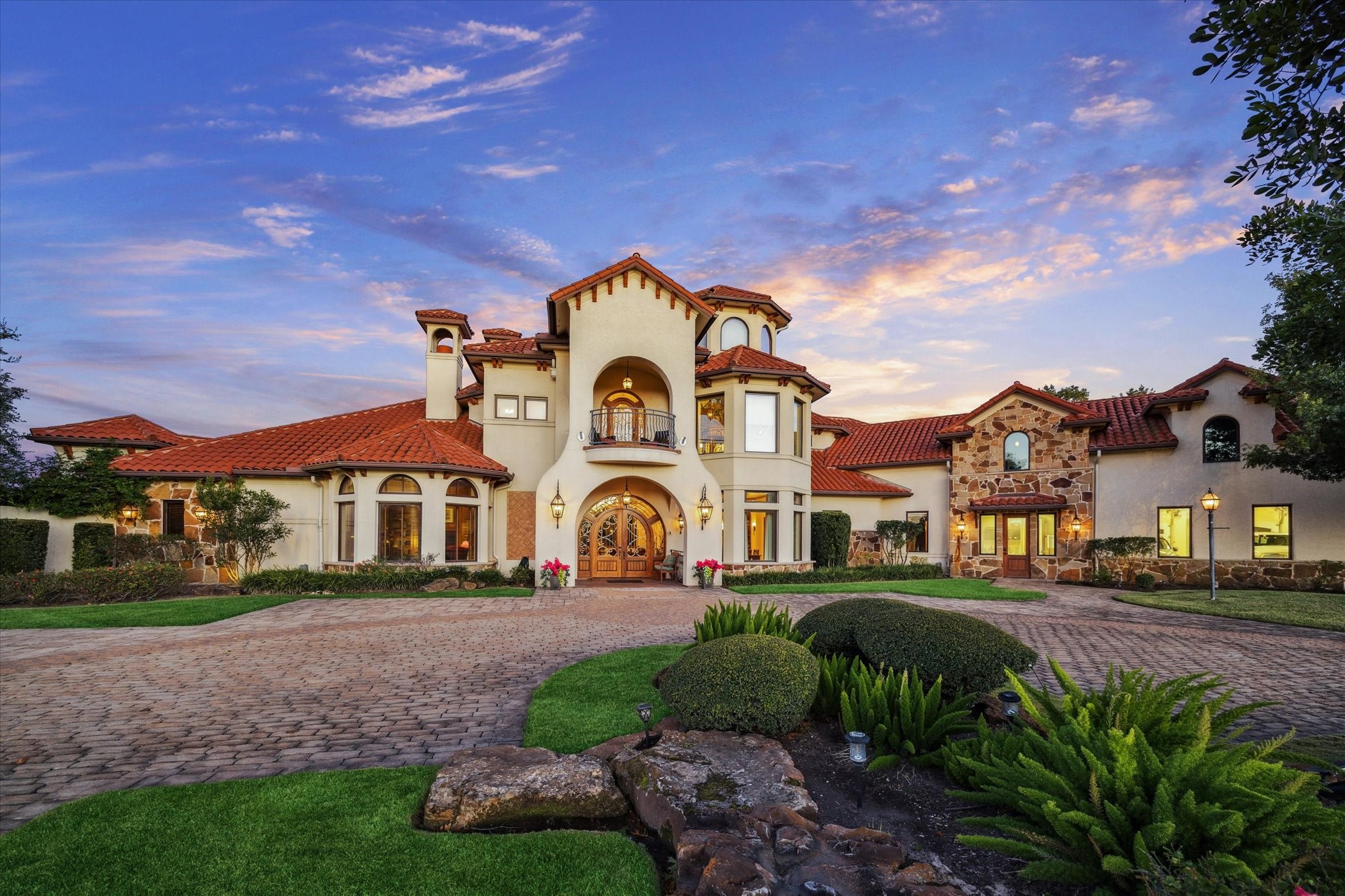 21538 Mueschke Road Tomball, TX 77377 - Photo 2 of 50 This magnificent Mediterranean-style estate welcomes you with a grand circular driveway and timeless architectural details. The exterior features a classic red tile roof, elegant stone accents, and arched entryways that exude sophistication. Lush landscaping surrounds the property, creating a serene and private setting. Perfectly designed for luxury living, this home combines elegance, comfort, and impressive curb appeal.