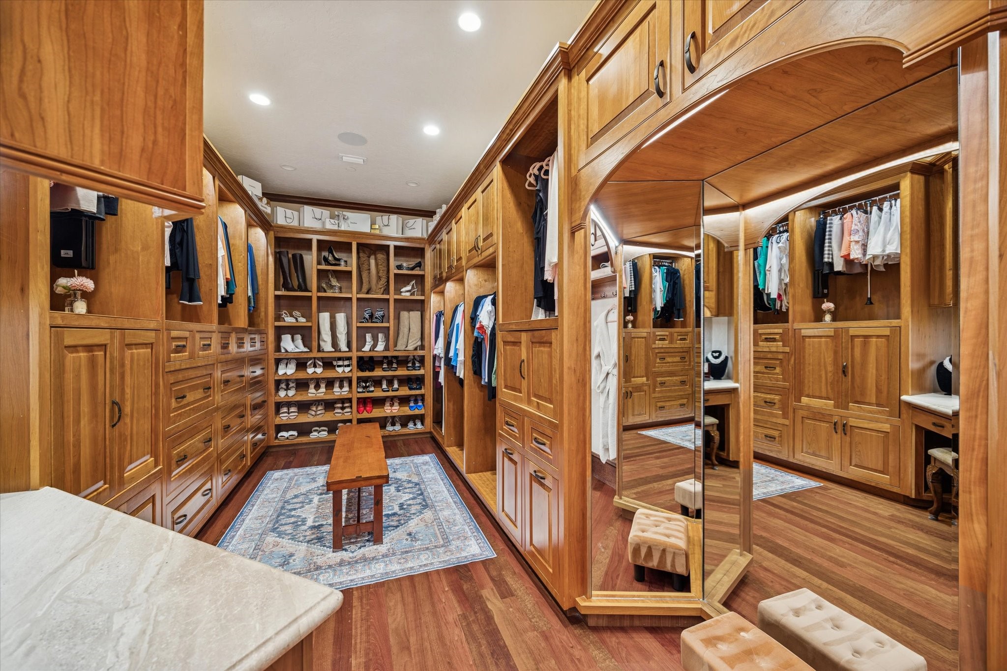 21538 Mueschke Road Tomball, TX 77377 - Photo 21 of 50 Spacious walk-in closet retreat. Step into a space designed to elevate your daily routine, where elegant wood accents and meticulously organized storage ensure every outfit, shoe, and accessory is perfectly in place. Multiple mirrors offer views from every angle, making preparation for work, social gatherings, or special evenings effortless and enjoyable. This exquisite closet transforms a simple dressing routine into a moment of luxury, confidence, and inspiration.