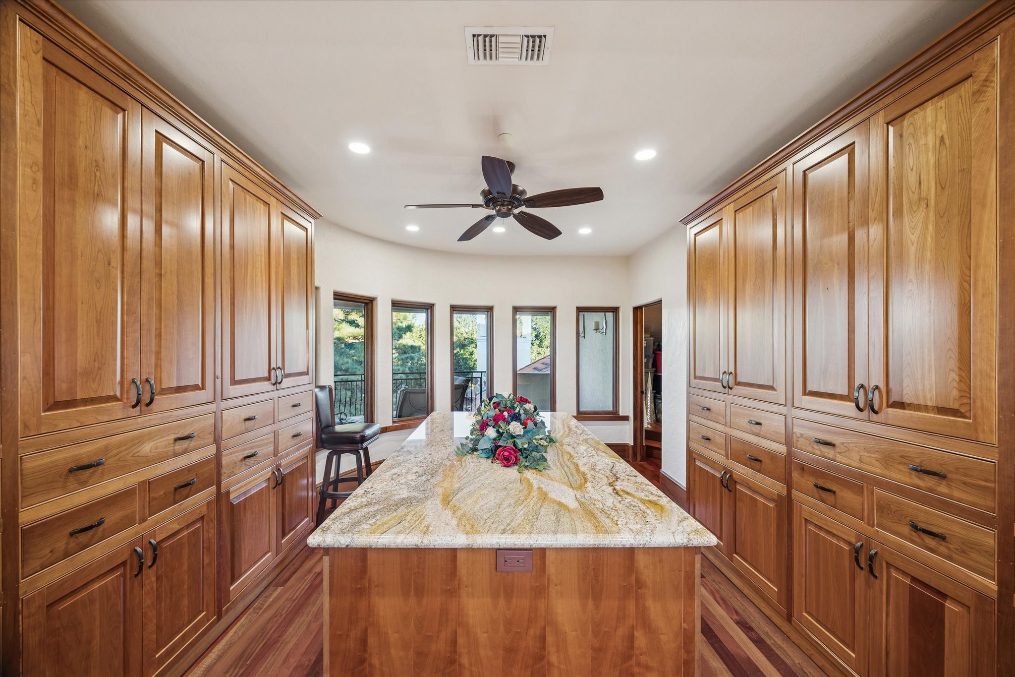 21538 Mueschke Road Tomball, TX 77377 - Photo 23 of 50 Elegant and versatile craft room located on the upper level of this stunning home. Featuring custom cabinetry and a spacious center island with built-in storage, this area is perfect for organizing art supplies, wrapping gifts, or keeping every creative detail within easy reach. Filled with natural light and overlooking the patio and balcony, this flexible space can also serve as an additional bedroom or office, refined, functional, and beautifully designed.