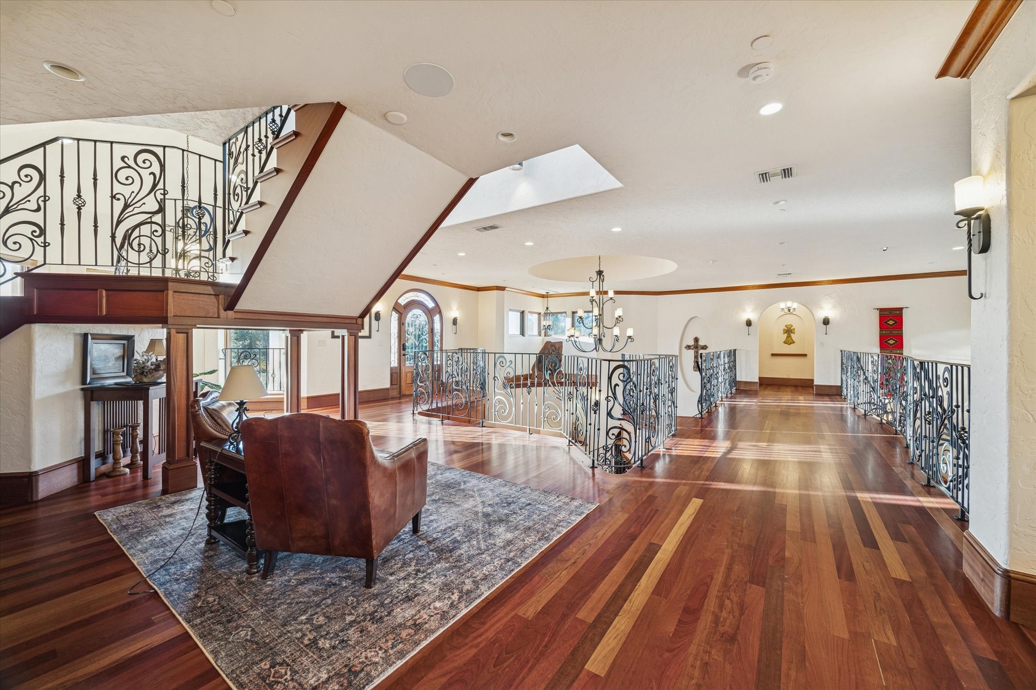 21538 Mueschke Road Tomball, TX 77377 - Photo 24 of 50 Ascending the grand staircase leads to an elegant second-level atrium bathed in natural light. The hand-forged steel railing, crafted as a single piece, adds a touch of artistry and sophistication. This serene space invites you to sit, read, or even showcase a piano, with beautiful built-in wooden drawers perfect for displaying books and treasured photos.
