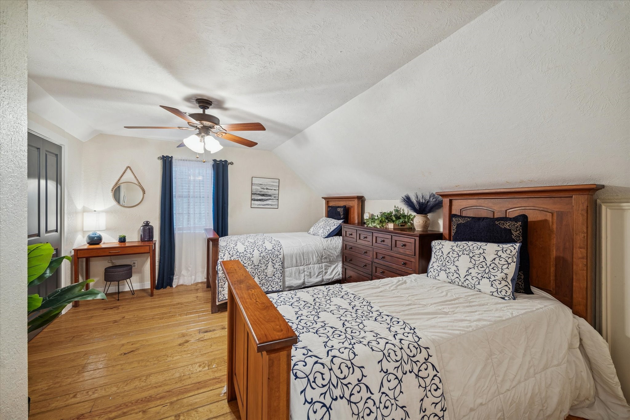 21538 Mueschke Road Tomball, TX 77377 - Photo 42 of 50 Spacious log cabin bedroom. Surrounded by mature landscaping and the serenity of nature, this inviting room offers generous space and comfort, providing a cozy retreat for guests who wish to enjoy the unique charm of this special cabin. Perfect as a primary home, guest house, or weekend getaway, it embodies peaceful luxury and relaxed elegance.