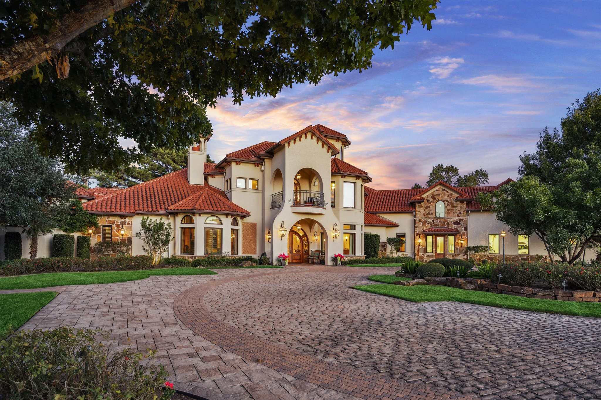 21538 Mueschke Road Tomball, TX 77377 - Photo 46 of 50 Stunning Mediterranean-style estate with timeless architectural details! This impressive residence features a grand arched entry, elegant balconies, and a striking tile roof that exudes sophistication. The circular drive and lush landscaping create a welcoming approach to this exceptional property. Perfectly designed for luxury living, this home combines classic charm with modern elegance.