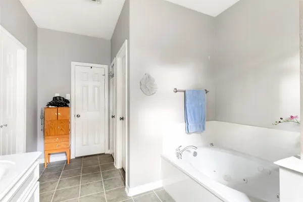a bathroom with a tub sink and a mirror
