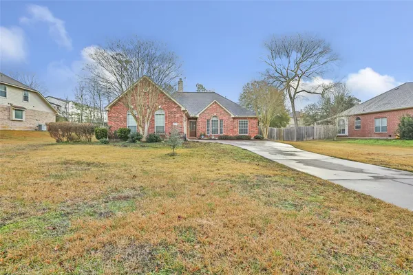 a view of a house with a big yard and large trees