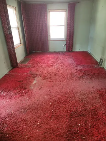 a view of a bedroom with a bed and a window