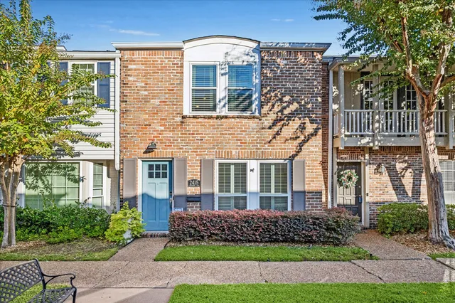 front view of a brick house with a yard