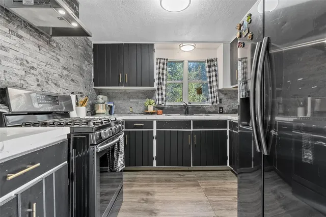 a kitchen with stainless steel appliances a stove a sink and a refrigerator