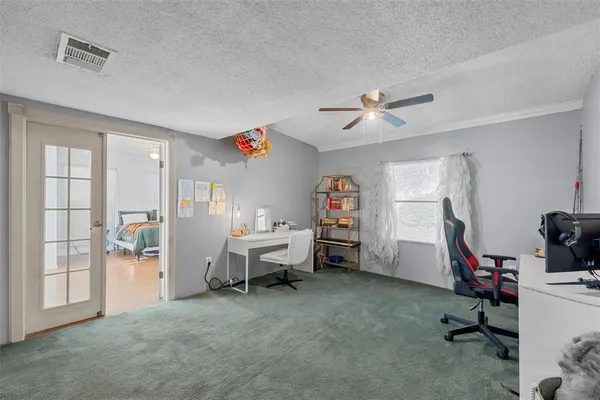 a view of a workspace with furniture and a ceiling fan