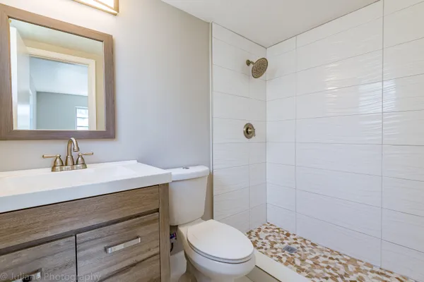 a bathroom with a sink a toilet and shower