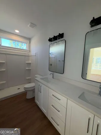 a bathroom with a toilet sink and mirror