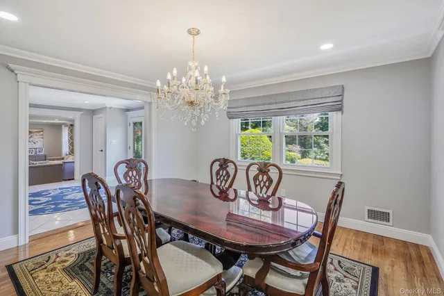a view of a dining room with furniture a chandelier and wooden floor