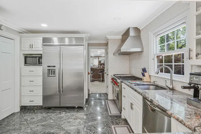 a kitchen with stainless steel appliances granite countertop a stove a refrigerator and a sink