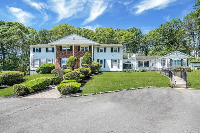 a front view of a house with a yard and potted plants