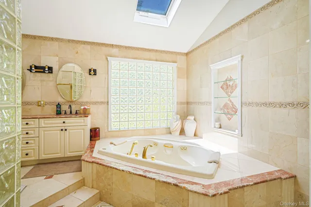 a spacious bathroom with a tub sink and mirror
