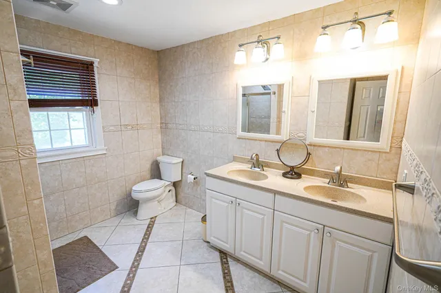a bathroom with a toilet a sink and mirror