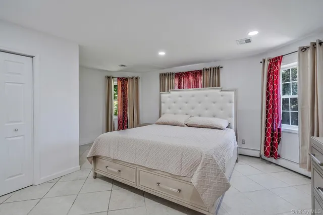 a spacious bedroom with a bed and a window