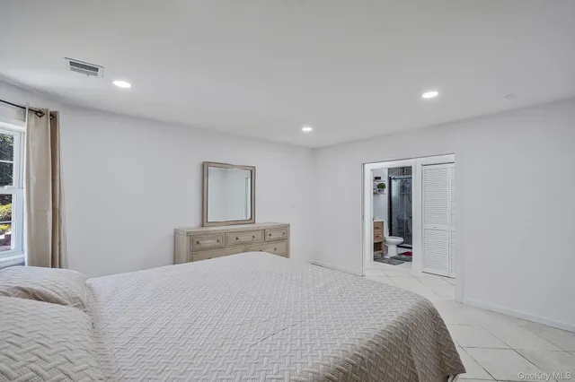 a bedroom with a large bed and dresser