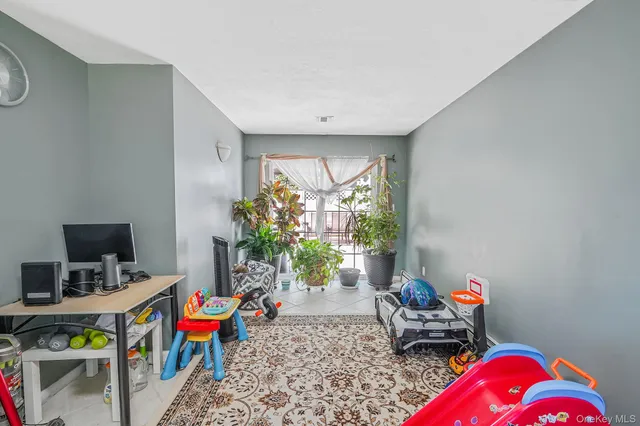 a living room with furniture a flat screen tv and a window