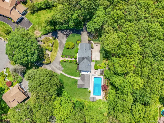 an aerial view of a house with a yard and swimming pool