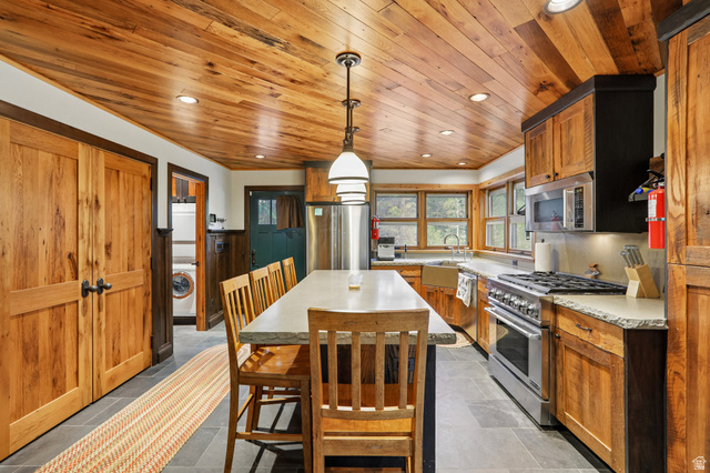 10205 East Moose Loop Road Salt Lake City, UT 84121 - Photo 11 of 50 Kitchen featuring wood-paneled ceilings, recessed lighting, and a central island with countertop seating